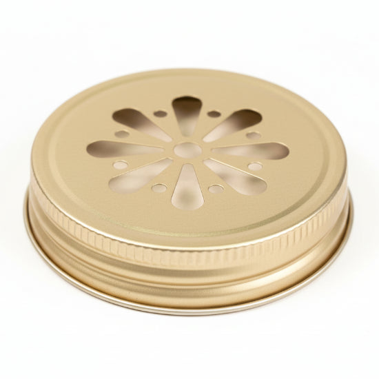 Metallic lid with decorative cut-out design on a neutral background