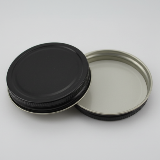 Two black metal lids on a white background
