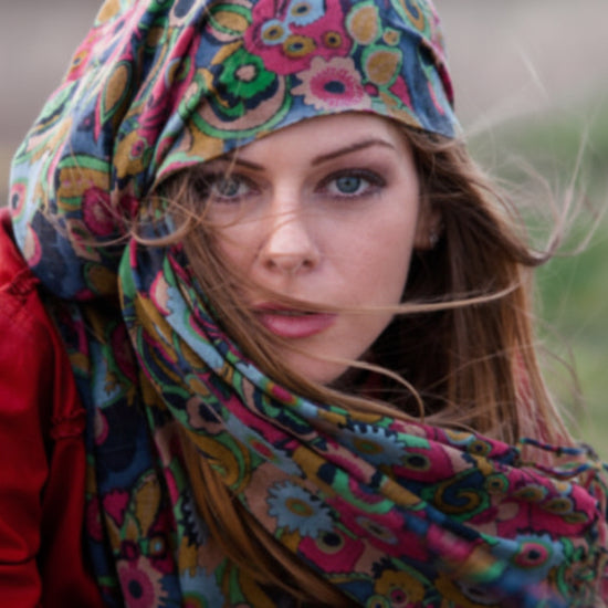 Woman wearing a colorful headscarf and red jacket outdoors