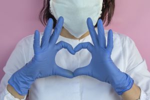 girl in latex gloves shows a heart shape.