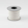 Spool of white thread on a gray background