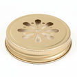 Metallic lid with decorative cut-out design on a neutral background