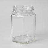 Clear glass hexagonal jar on a white background