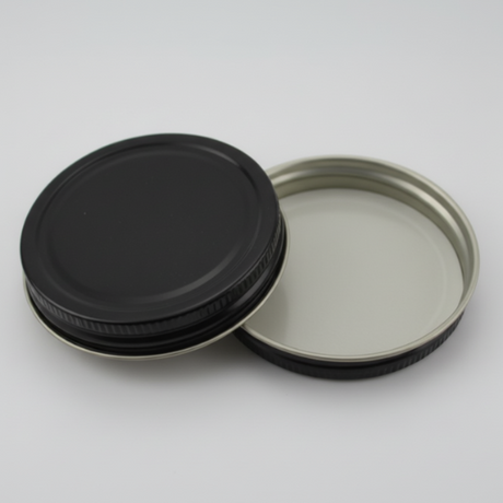 Two black metal lids on a white background