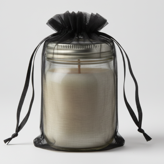 Candle in a glass jar with a black drawstring bag on a white background