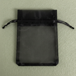 Black drawstring pouch on a light green background