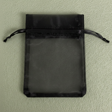 Black drawstring pouch on a light green background