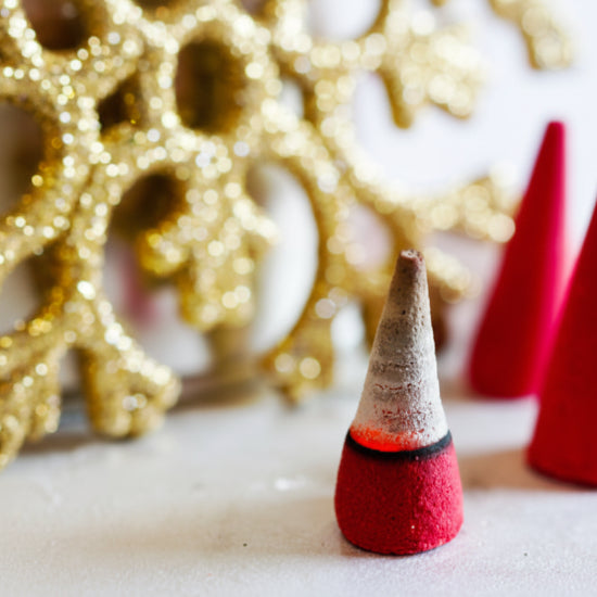 Decorative red and gold cones with a glittery gold snowflake in the background.