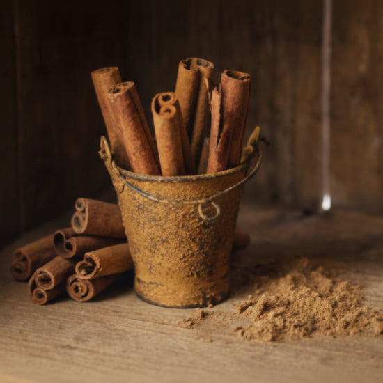 Cinnamon sticks in a rustic container on a wooden surface