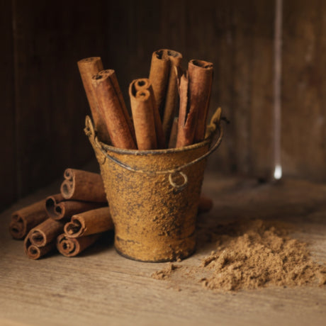 Cinnamon sticks in a rustic container on a wooden surface