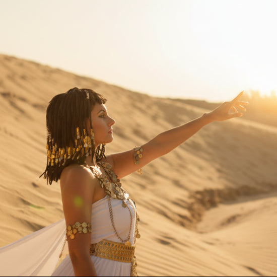 Woman in a desert setting with sand dunes and sunlit background