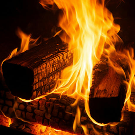 Close-up of burning wood with flames in a dark setting