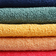 Stack of colorful towels in blue, green, yellow, orange, and red.