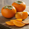 Persimmons on a wooden cutting board with a knife
