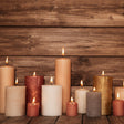 Gray candles of various sizes on a wooden surface with a wooden background