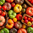 Assorted tomatoes including red, green, and yellow varieties on a wooden surface.