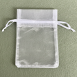 White organza drawstring bag on a green background