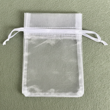 White organza drawstring bag on a green background