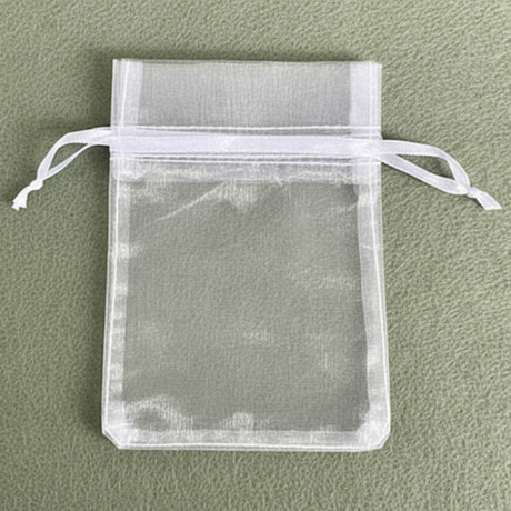 White organza drawstring bag on a green background