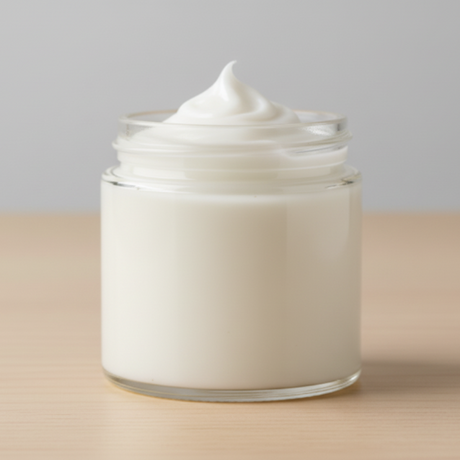 Jar of white cream on a beige surface with a gray background