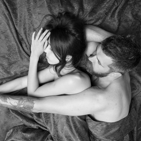 Black and white photo of a couple lying on a bed