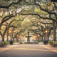 a park in new orleans with fountain and moss covered trees