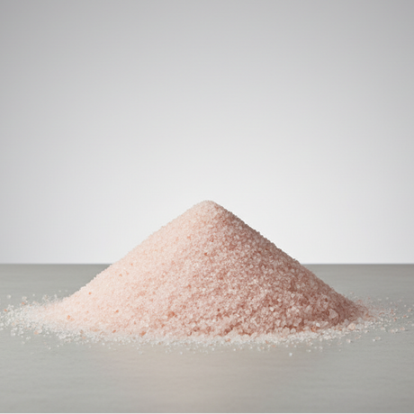 Pile of pink salt on a gray surface with a light gray background