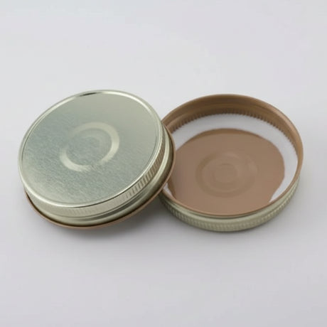 Gold button mason jar lids on a white background