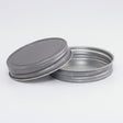 Two metal jar lids on a white background