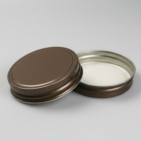 Two metal jar lids on a white background