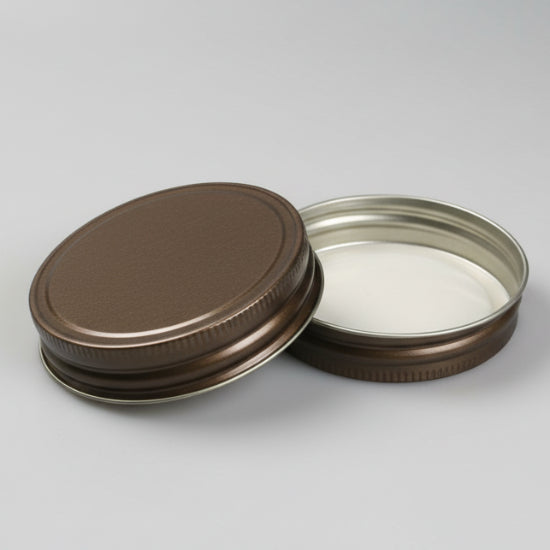 Two metal jar lids on a white background